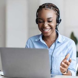 Online algebra tutors. Black female tutor in headset having video conference with laptop