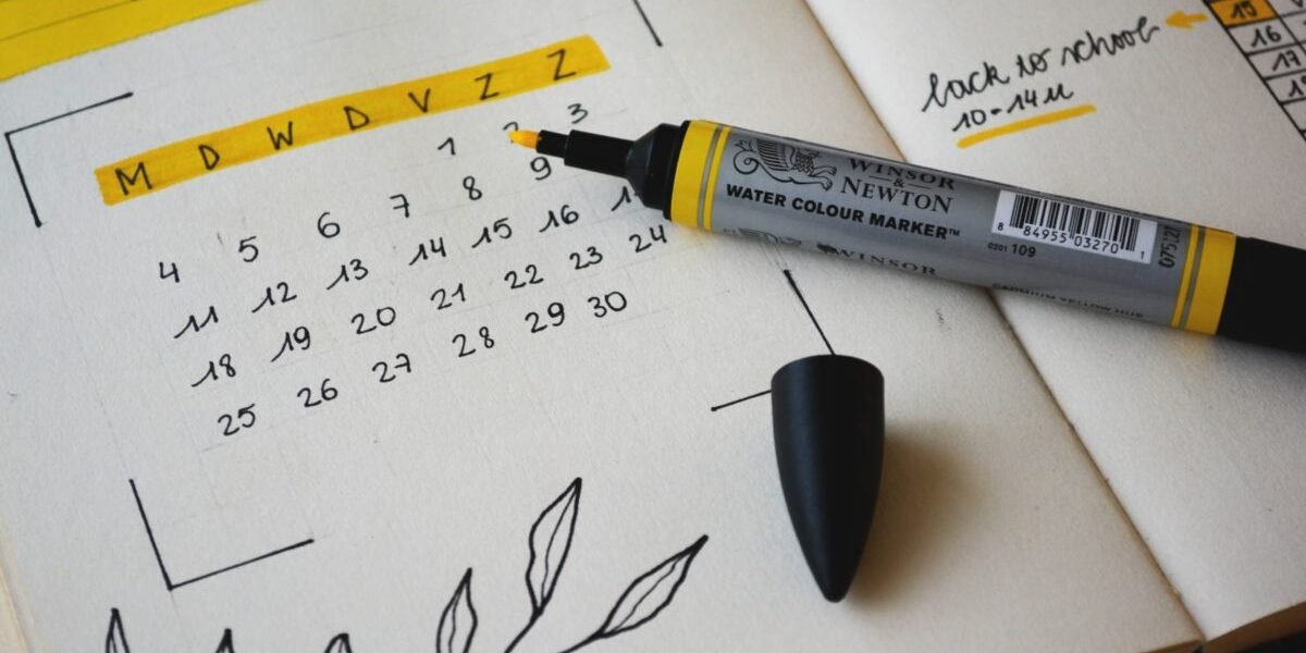 Picture of a handwritten homework calendar in a journal using black pen and a yellow highlighter