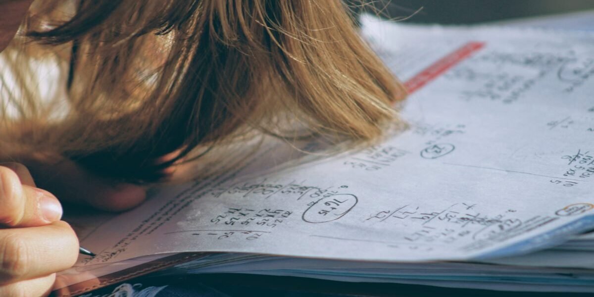 A frustrated student with his head on his notebook